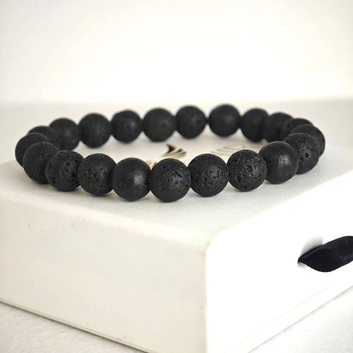 Close-up of black lava stone beads showing raw volcanic texture and natural pores