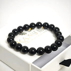 Black obsidian crystal bracelet inside a branded jewelry pouch, perfect for gifting.