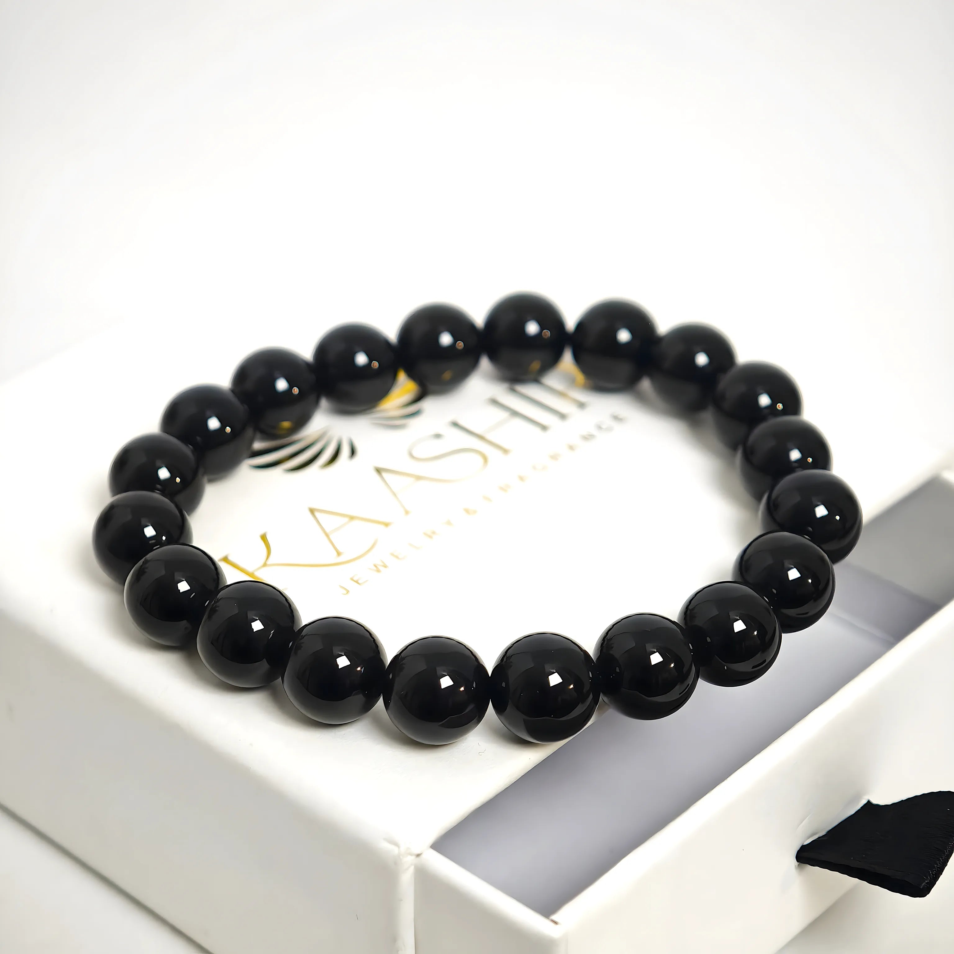 Black obsidian crystal bracelet inside a branded jewelry pouch, perfect for gifting.