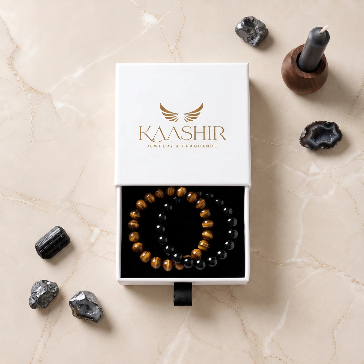Kaashir 8mm black obsidian and tiger eye bracelet set in a white drawer gift box on a marble surface