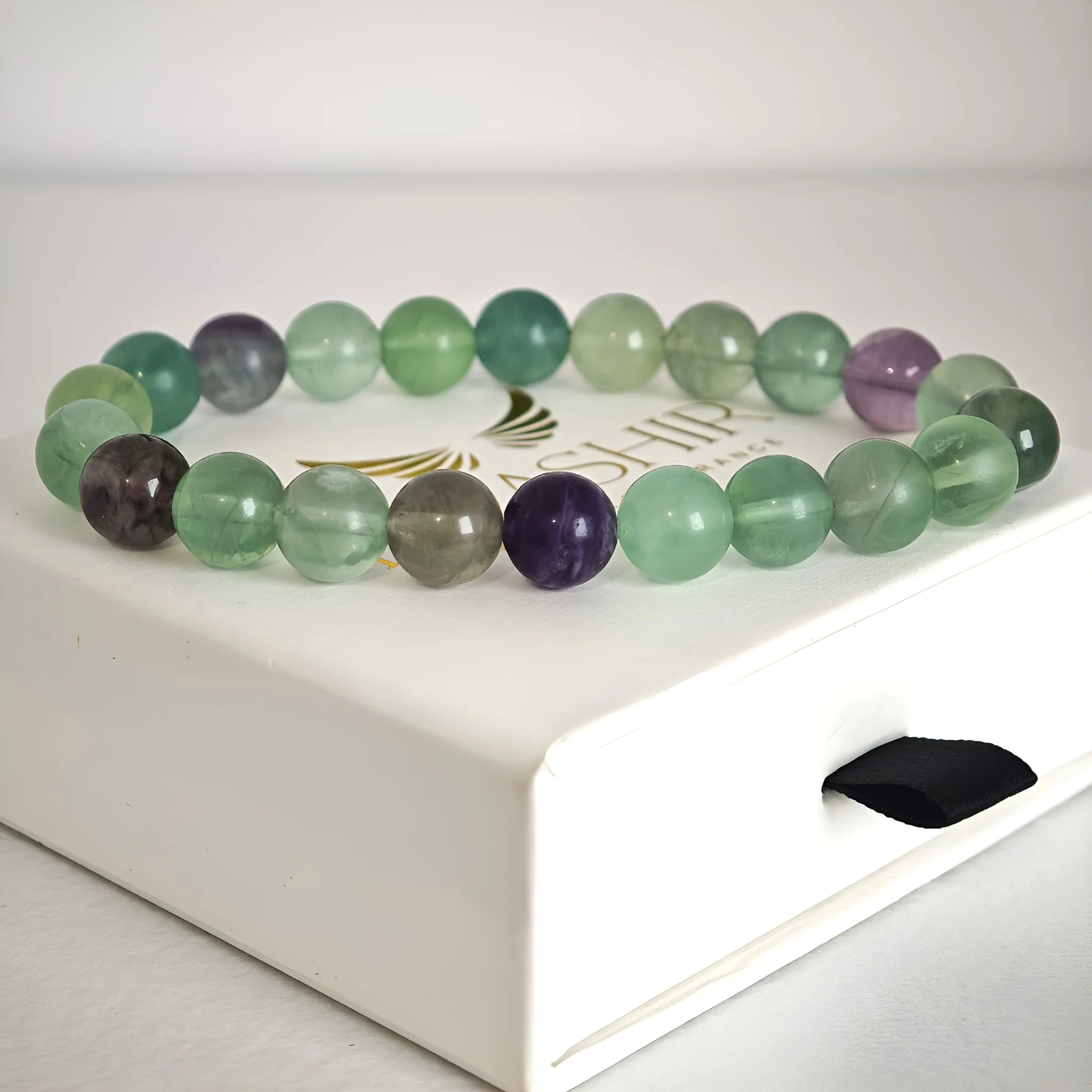 Close up of fluorite bracelet beads showing natural green and purple tones
