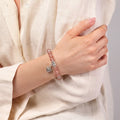 Strawberry quartz heart charm bracelet worn on woman's wrist — pink gemstone for love and compassion