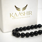 Close-up of genuine black obsidian beads showing the volcanic glass luster and smooth surface.