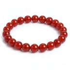 Red Agate natural gemstone beaded bracelet with glossy deep red beads on white background