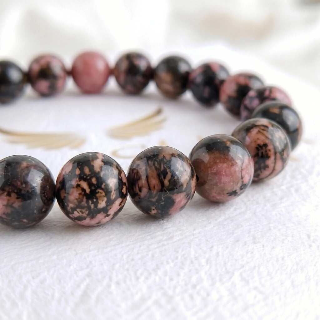 Close-up of genuine rhodonite bracelet beads showing natural pink and black pattern