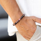 Rhodonite bracelet worn on man's wrist — unisex emotional balance stone bracelet