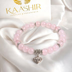 Close-up of genuine rose quartz bead bracelet with sterling silver ornate heart charm