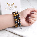 Triple protection bracelet stacked with crystal bracelets on wrist